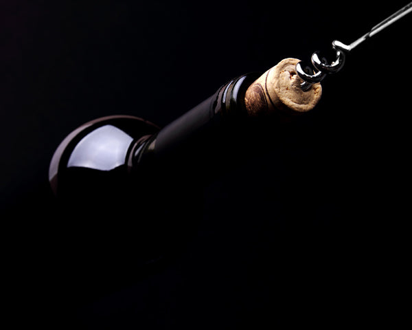 Bottiglia e cavatappi, sfondo nero